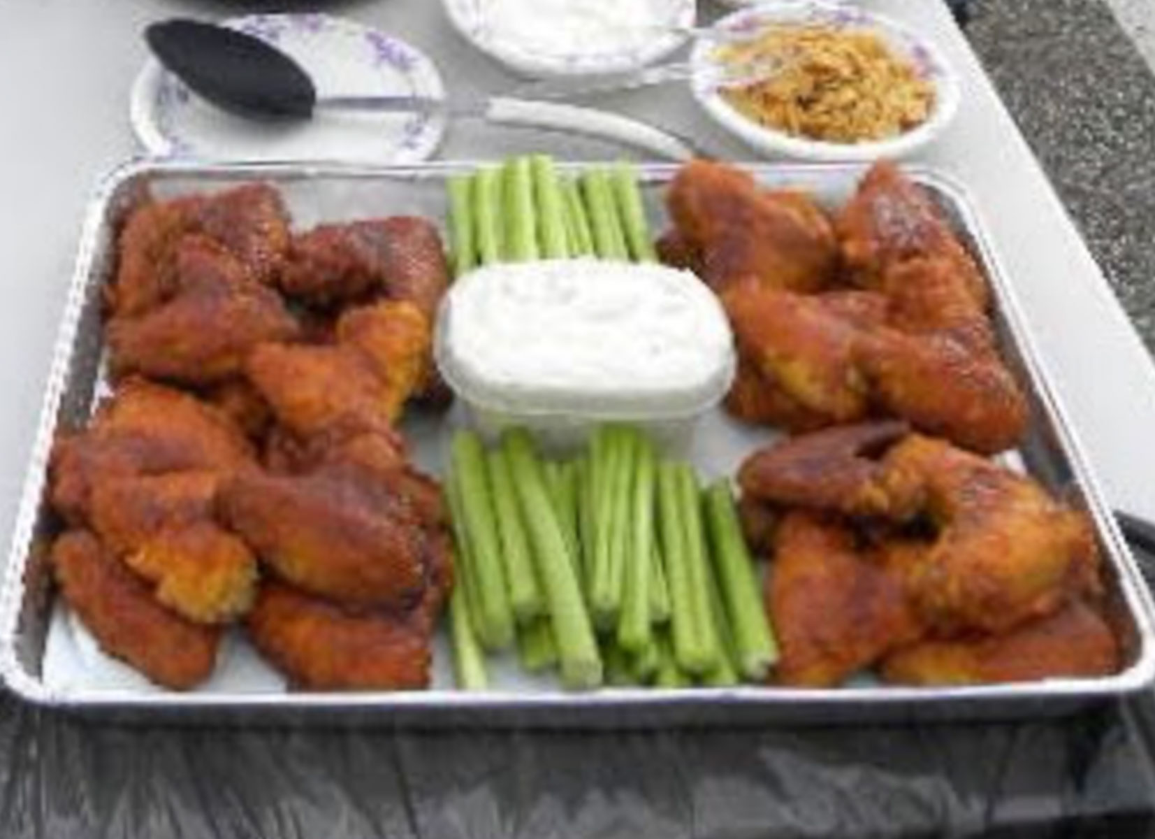 pan of bbq wings with celery and ranch in the middle of the pan