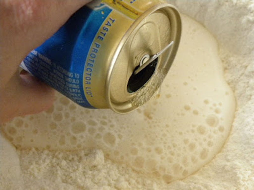 pouring a can of beer into dry ingredients for beer bread