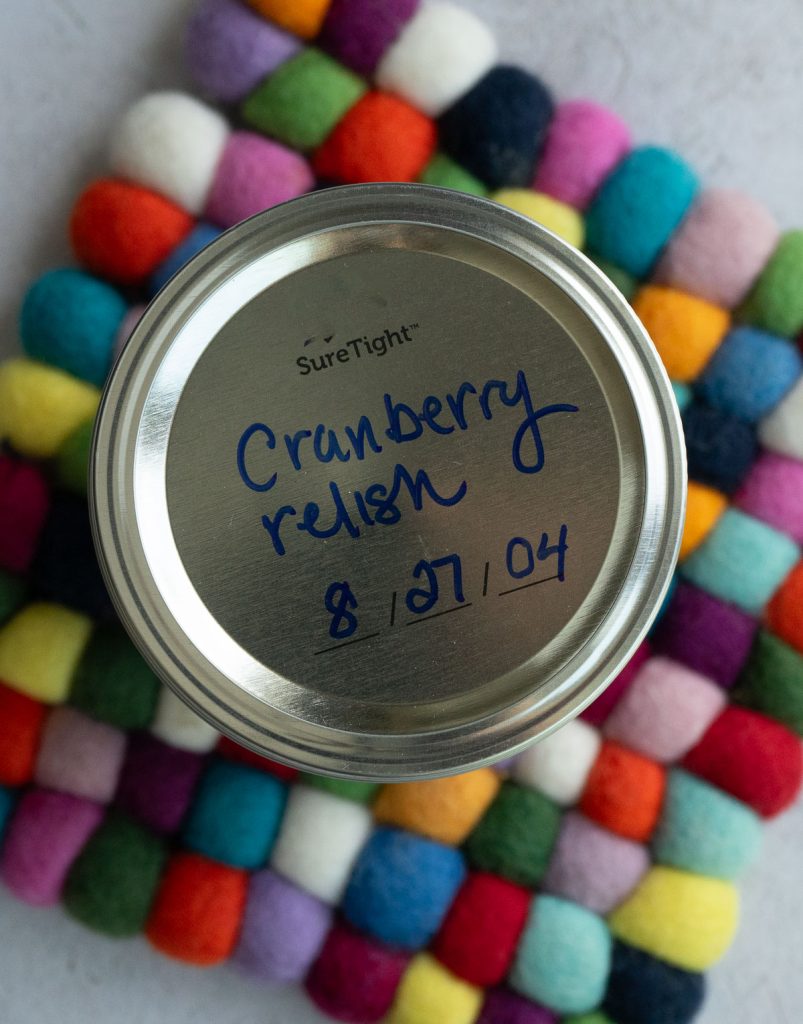 cranberry relish in a mason jar, view of mason jar from the top with cranberry relish written on the top with the date it was made