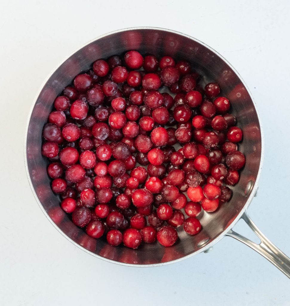 cranberries in a medium sized sauce pan on a gray background