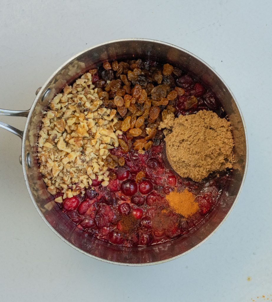 all ingredients added to cranberries in saucepan