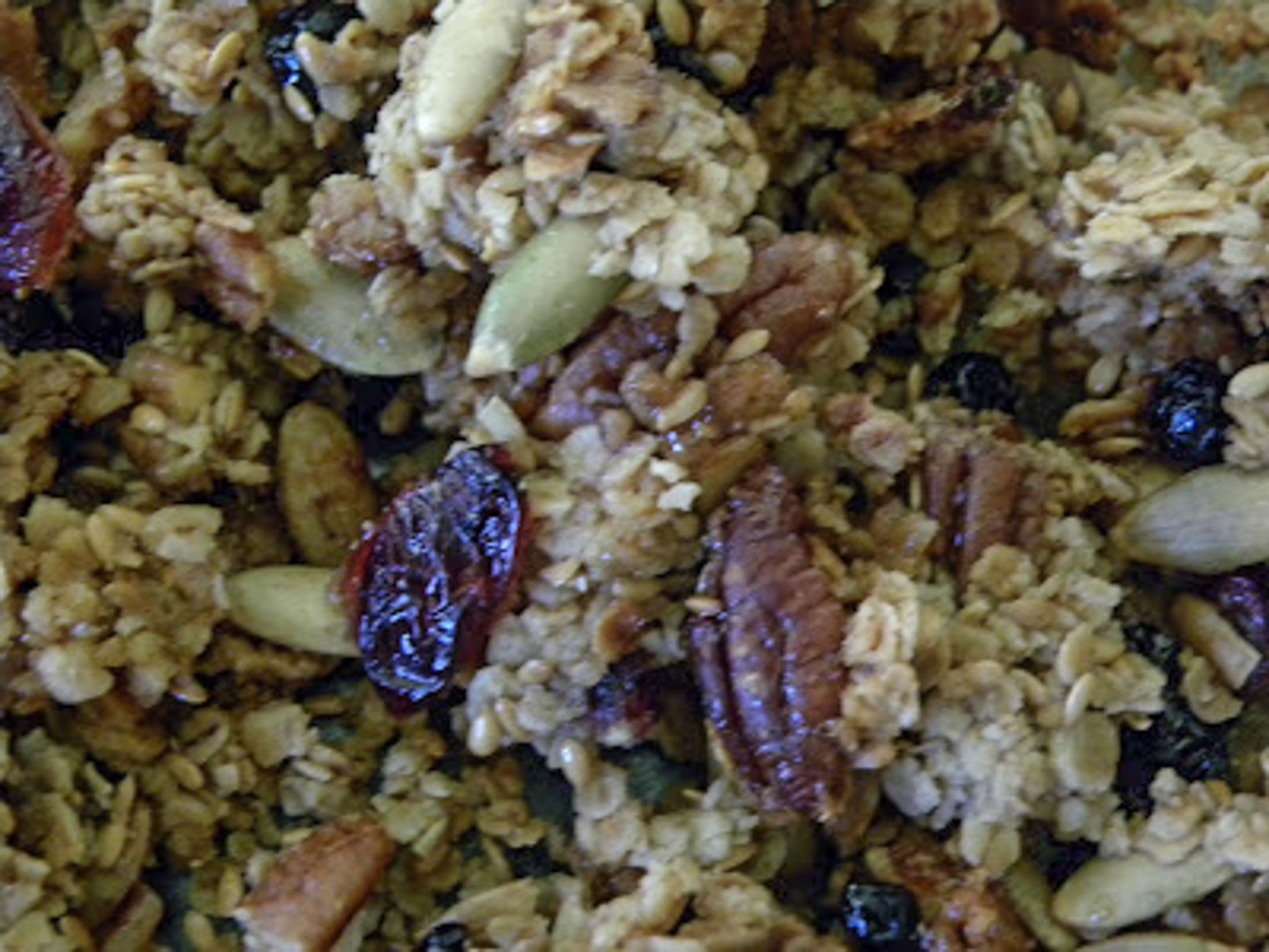 close up photo of homemade granola with pepitas, pecans, oats and dried fruit