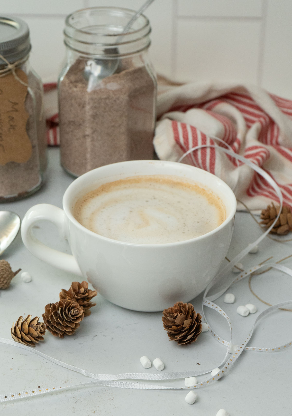 cup of instant mocha cappuccino mix in a white mug with a mason jar full of the dry mix