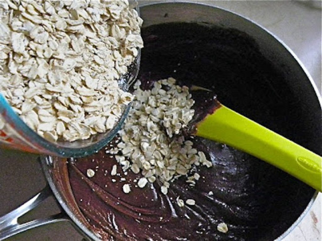 Adding rolled oats to no-bake cookie fudge in a saucepan 