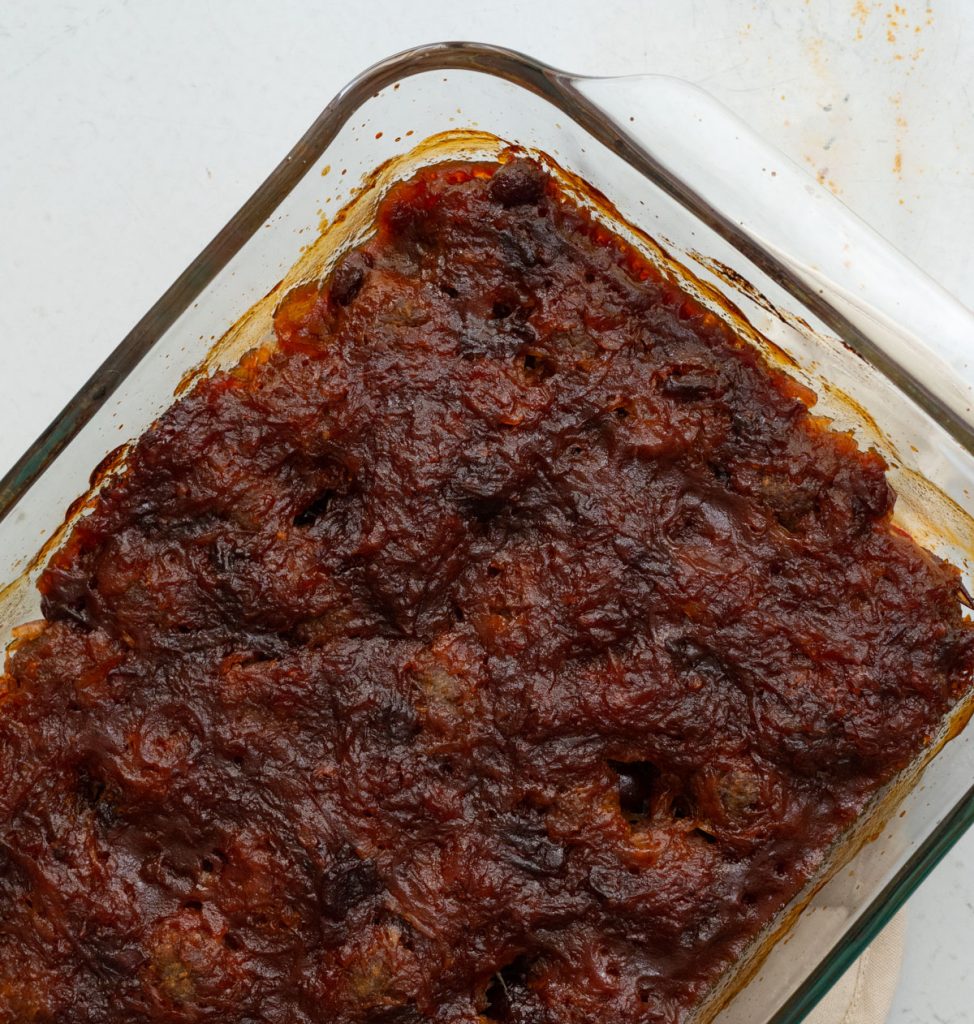 baked appetizer meatballs in a glass dish on a gray countertop