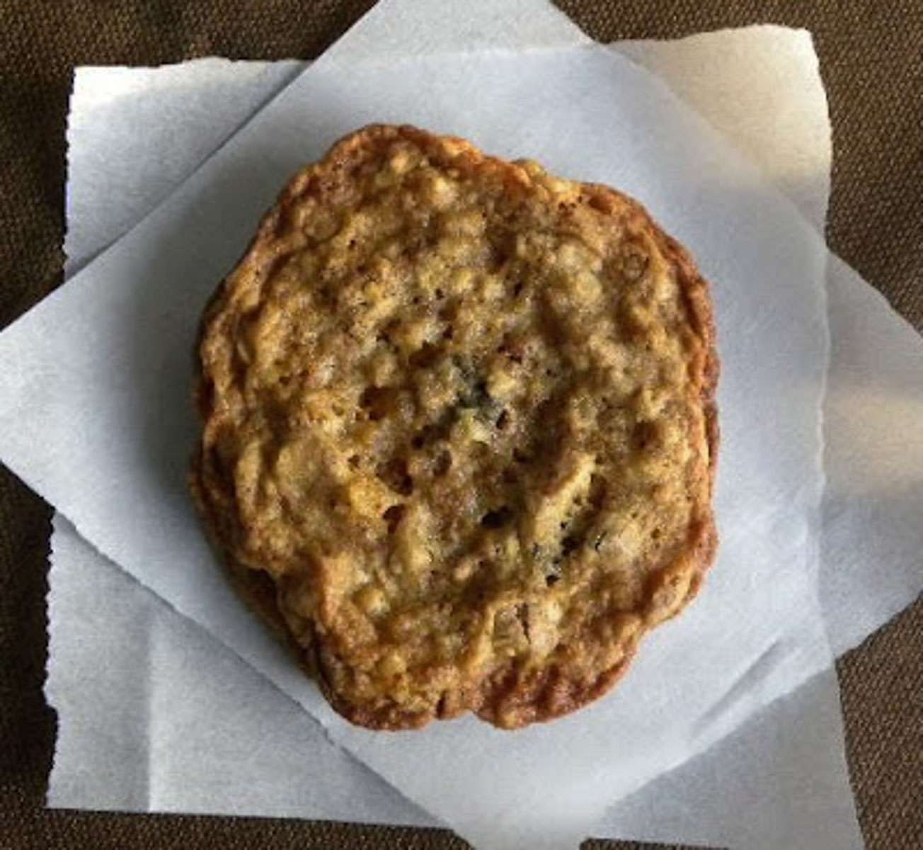 one granola cookie on a piece of parchment paper