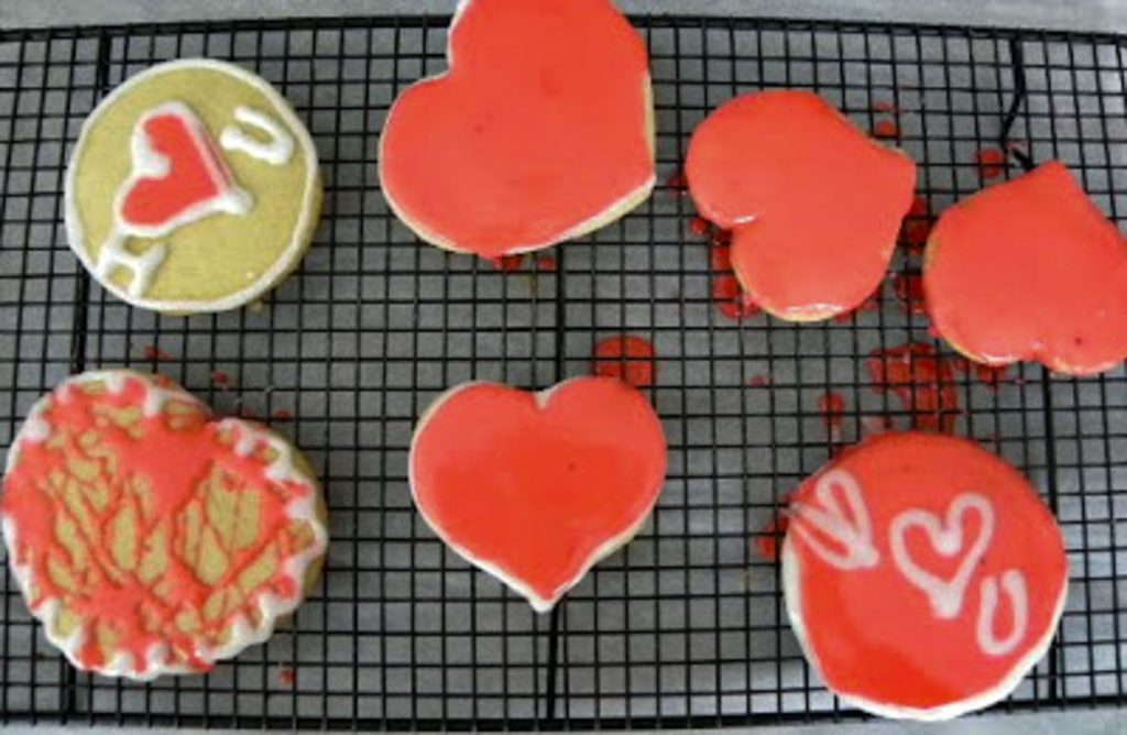 decorated heart and round sugar cookies on a cooling rack