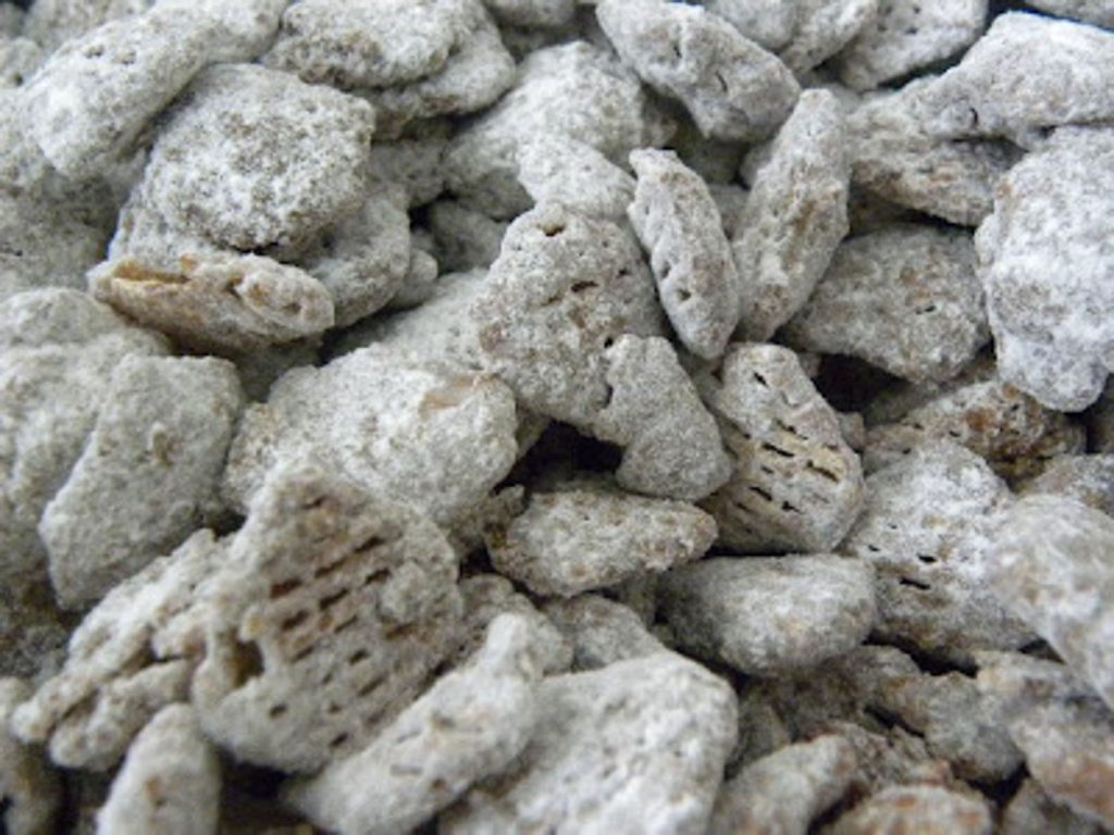 Puppy chow is a no-bake treat made by covering crispex cereal in a chocolate and peanut butter candy coating and tossing it in powdered sugar.