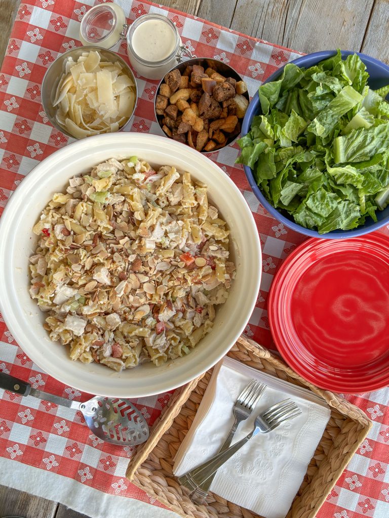 chicken caesar pasta salad with ingredients to be added in order at the top parmesan cheese, caesar dressing, croutons, romaine lettuce