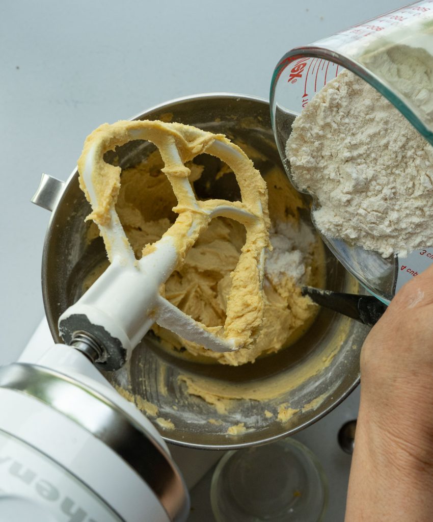 adding flour to sugar butter mixture for chocolate chip cookies