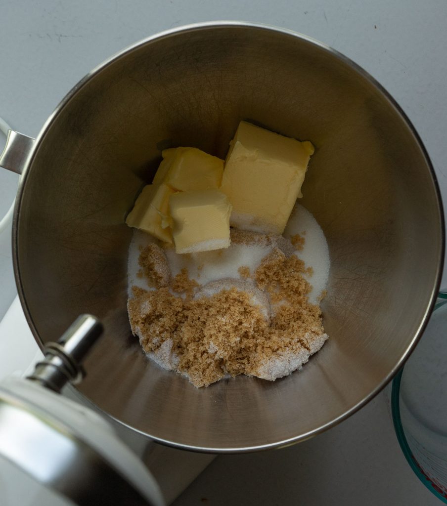 butter and white and brown sugar in a silver mixing bowl