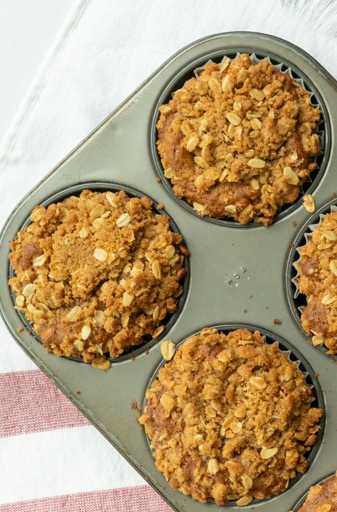 oatmeal breakfast muffins in muffin tin with white and red kitchen towel in the background