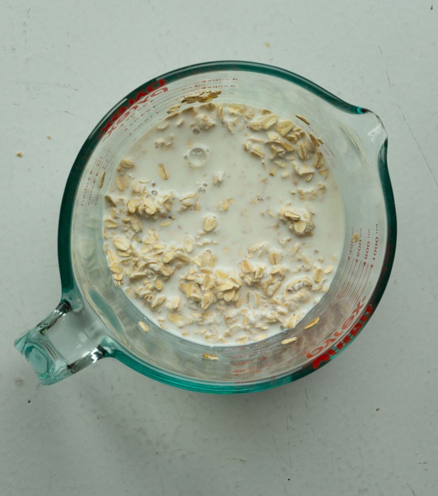 buttermilk and oatmeal in a glass measuring cup on gray table