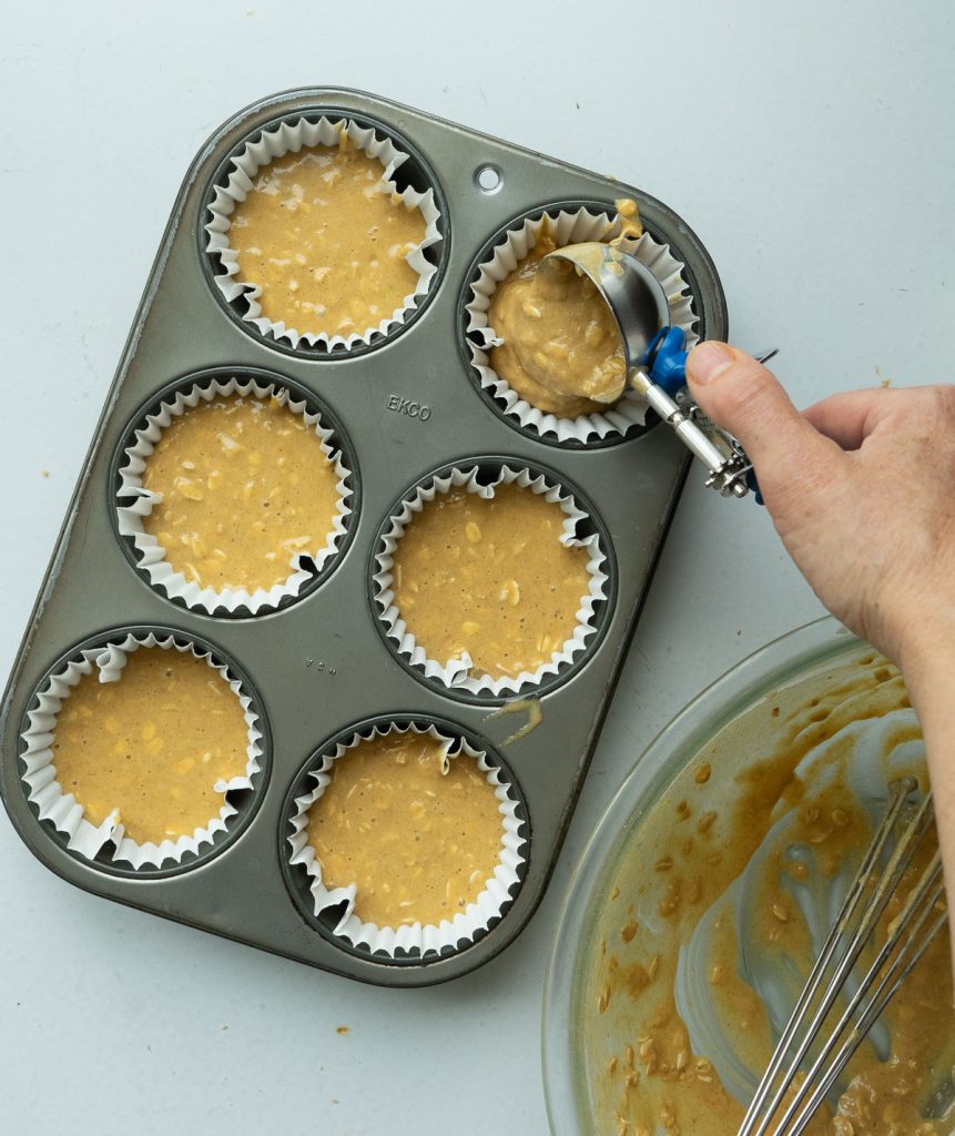 putting oatmeal muffin batter in muffin tins