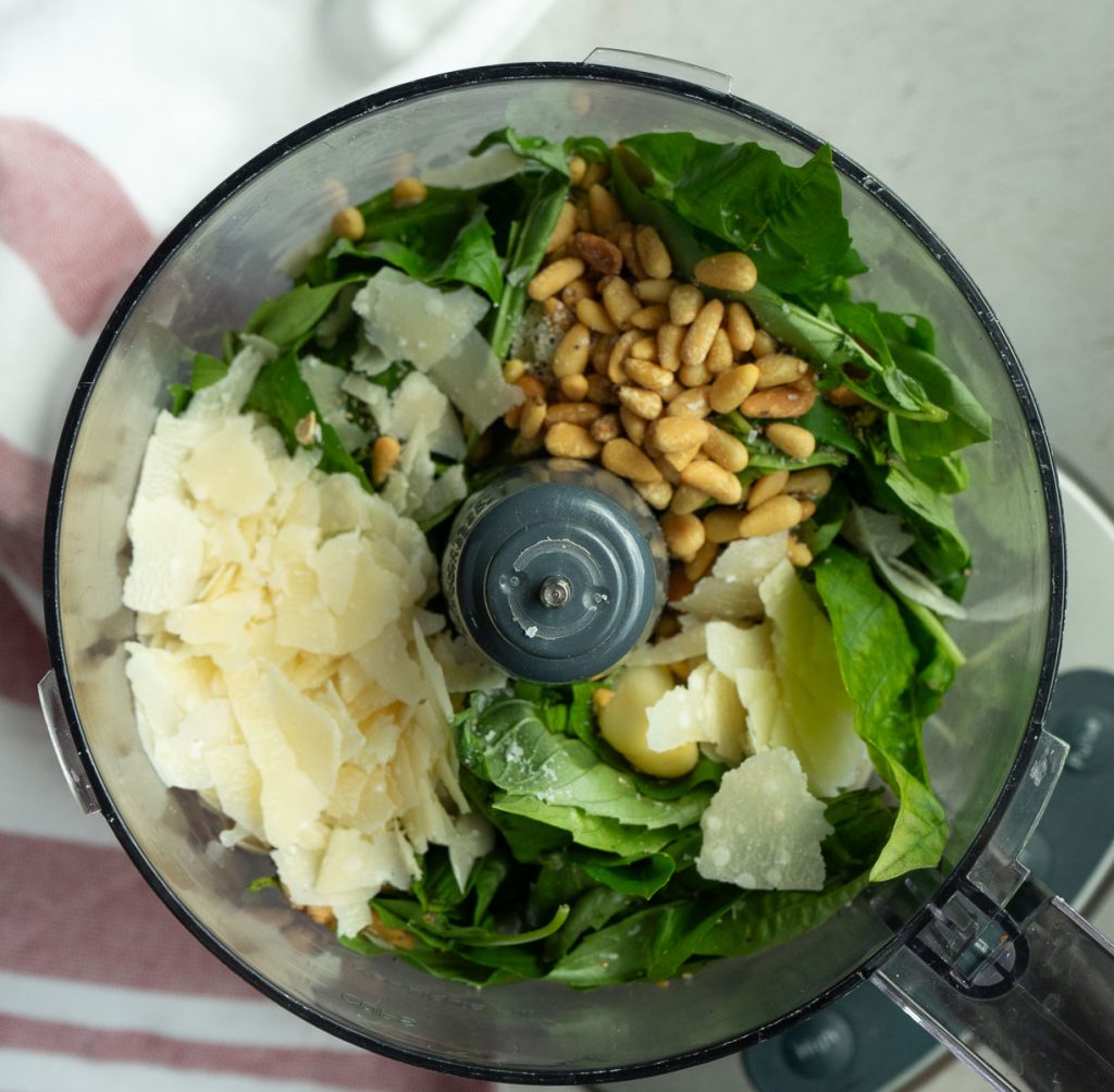 basil, parmesan, pine nuts, and garlic in the bowl of food processor