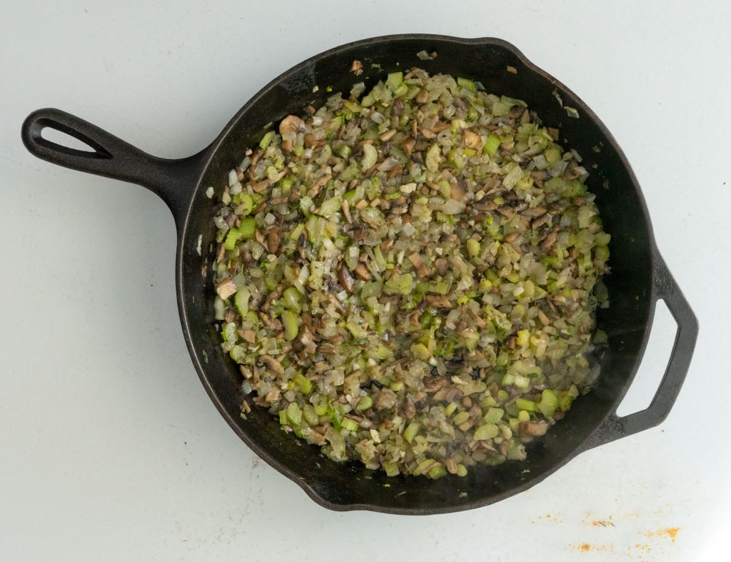 cooked vegetables in a cast iron skillet for crockpot stuffing