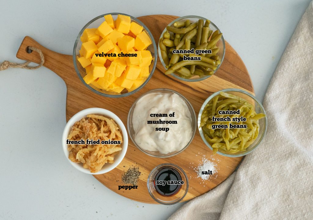 green bean casserole ingredients on a round wooden cutting board gray background