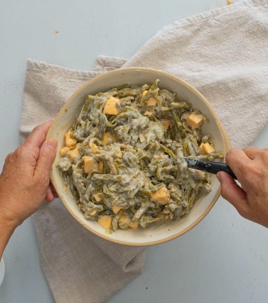 mixing velveeta cheese into  green bean casserole 