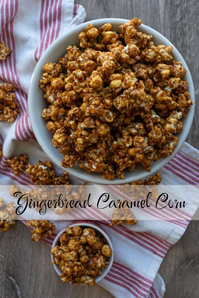 gingerbread caramel corn in a large bowl, with a smaller bowl in the lower left corner caramel corn is strewn over a red and white stripped kitchen towl