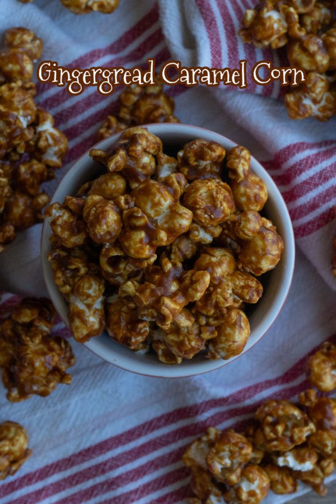 small dish of gingerbread caramel corn on a red white striped cloth with caramel corn laying around the dish