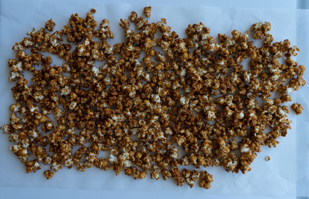 finished gingerbread caramel corn cooling on parchment paper