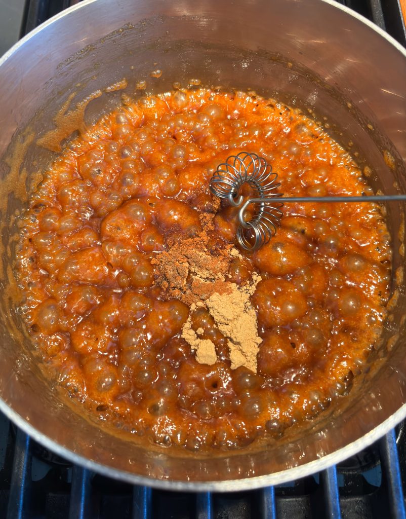 Adding gingerbread spice mixture to caramel sauce