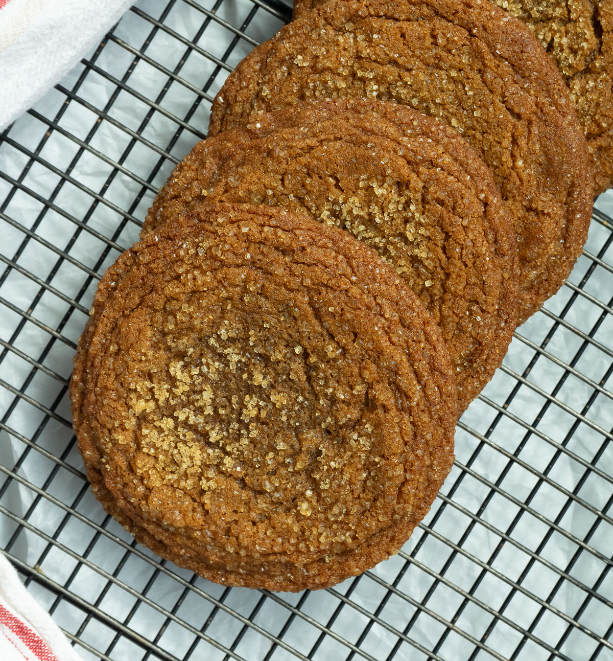 row of molasses cookies cooking on a wire rack on a gray counter top