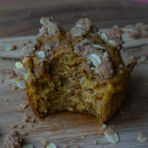 Pumpkin Oatmeal Breakfast Muffin with a bite out of it on a wood cutting board