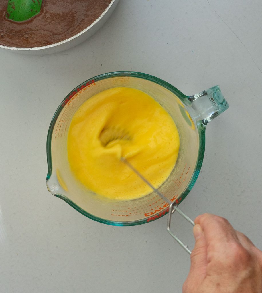 mixing egg, buttermilk, and baking soda in a large glass measuring dish