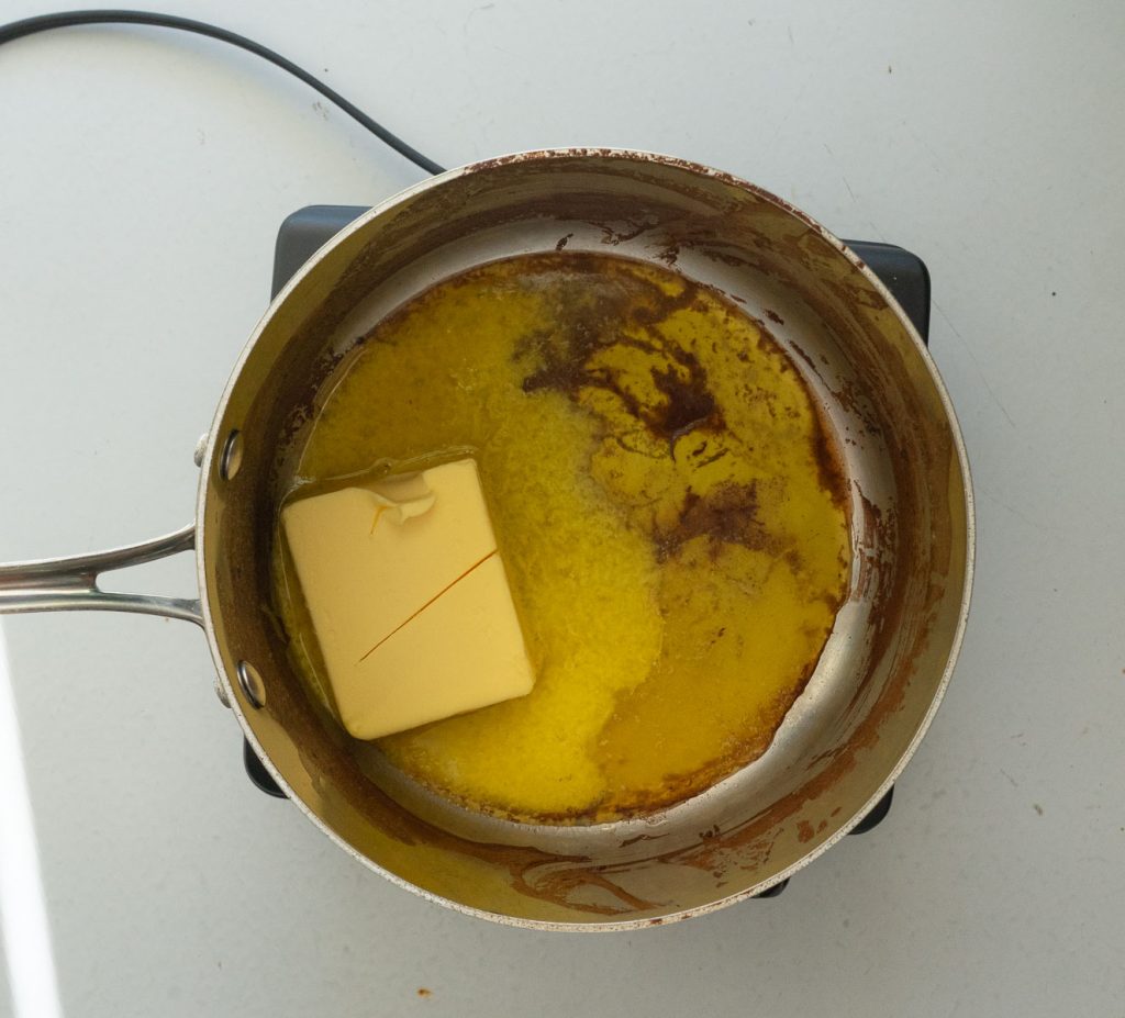 melting butter in a saucepan for michigan style texas sheet cake recipe