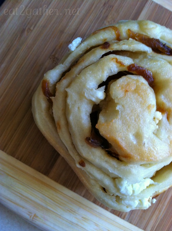 caramelized onion and goat cheese dinner roll on a wood surface