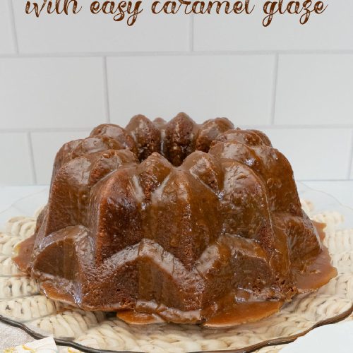 caramel toffee bundt cake on a glass platter with serving utensils and napkins in the forground