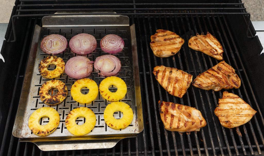 pineapple, red onion slices and chicken on grill 