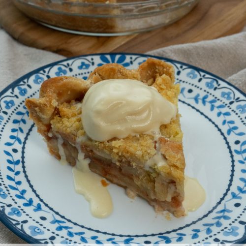 slice of dutch apple pie on a plate with ice cream dripping off