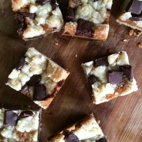 salted caramel chocolate chunk bars cut into squares and placed on a wood countertop