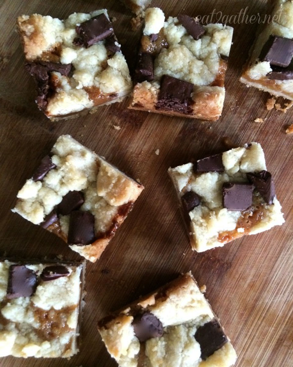 salted caramel chocolate chunk bars cut into squares and placed on a wood countertop