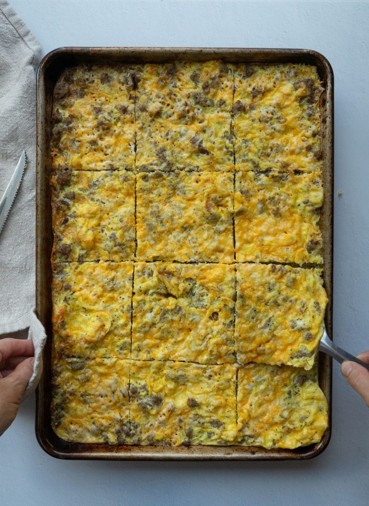baked egg, sausage, and cheese in a baking sheet cut into squares.