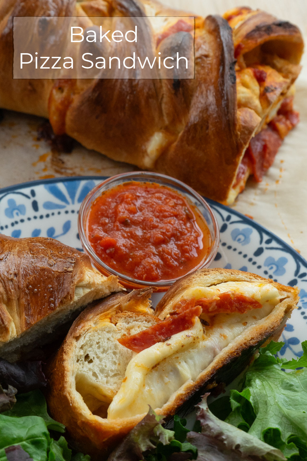 Baked Pepperoni Pizza sandwich slices on a plate with green salad on the side and a small dish of pizza sauce for dipping