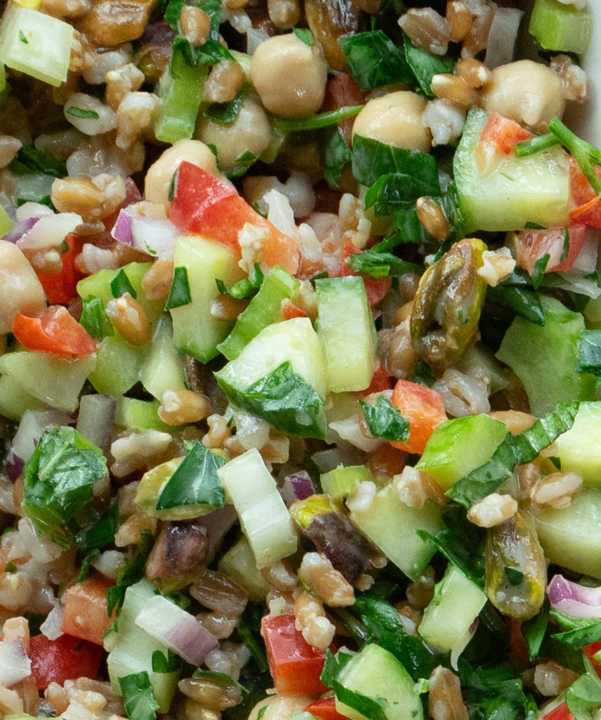 close up of farro salad. cucumber, red bell pepper, farro grains, chopped herbs celery onion