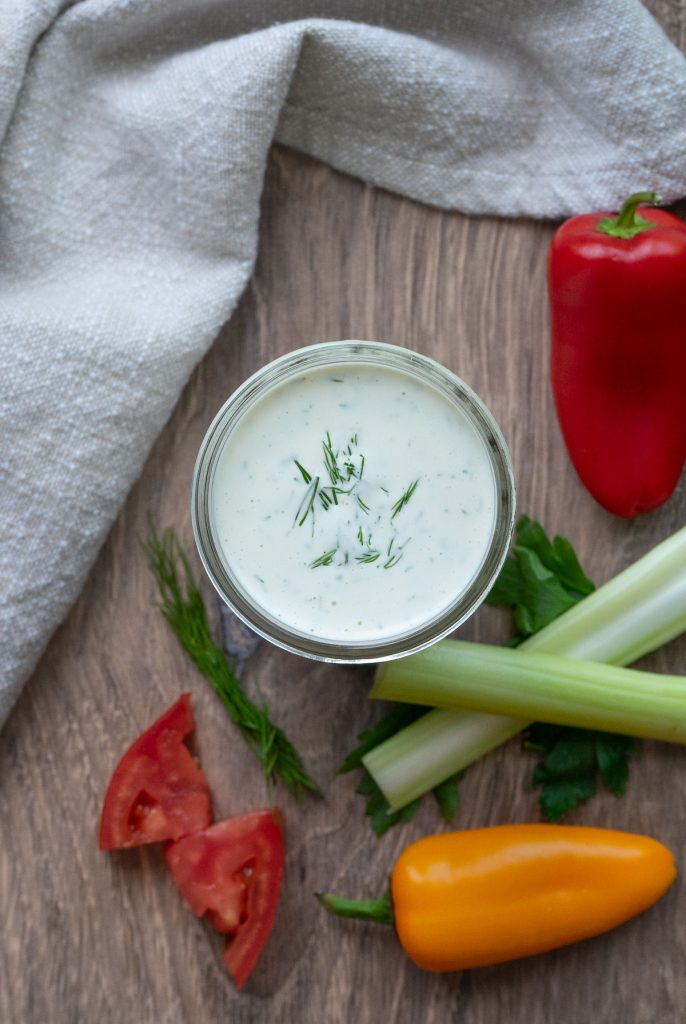 jar of buttermilk ranch dressing surrounded by vegetables for dipping