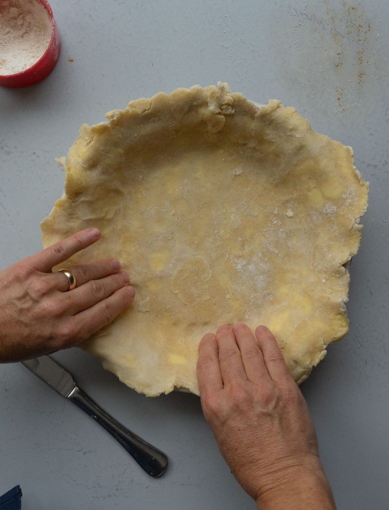 forming pie crust into a pie plate