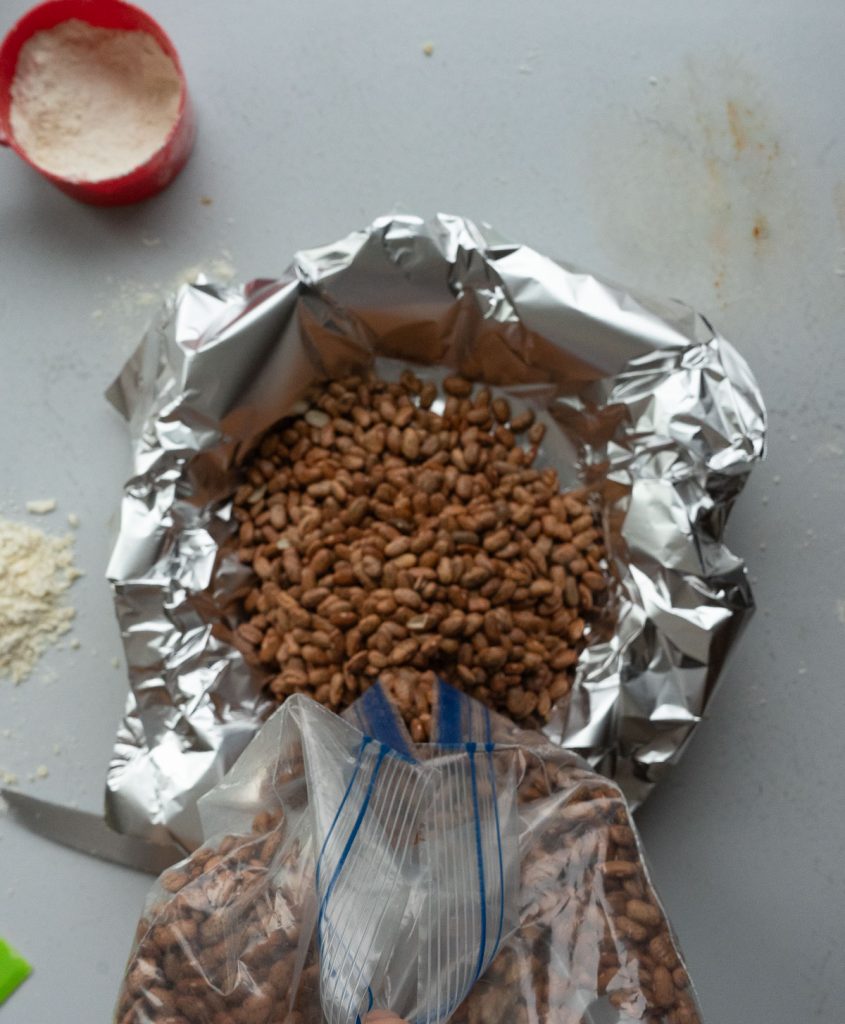 poring dried beans into the foil lined pie crust